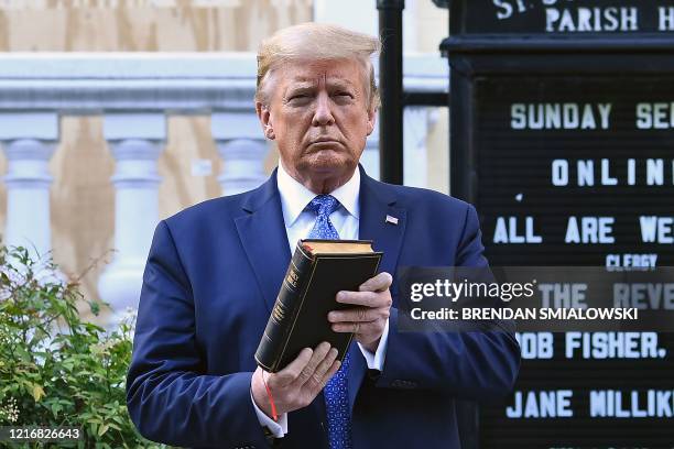 President Donald Trump holds up a Bible outside of St John's Episcopal church across Lafayette Park in Washington, DC on June 1, 2020. - US President...