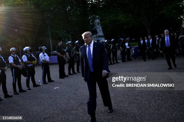 President Donald Trump walks back to the White House escorted by the Secret Service after appearing outside of St John's Episcopal church across...