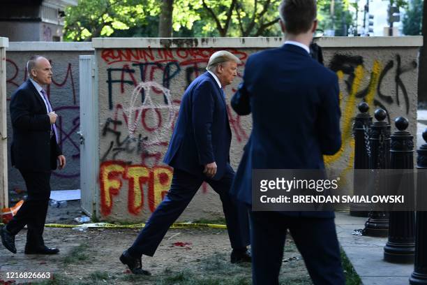President Donald Trump walks back to the White House escorted by the Secret Service after appearing outside of St John's Episcopal church across...