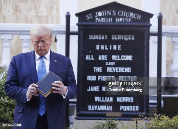 President Donald Trump poses with a bible outside St. John's Episcopal Church after a news conference in the Rose Garden of the White House in...
