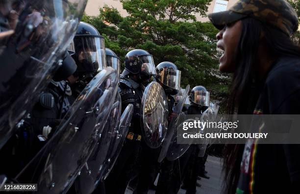 Protester screams in front of a row of police officers during a demonstration against the death of George Floyd at a park near the White House on...