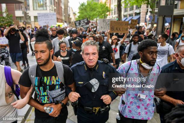 Denver Police Chief Paul Pazen links arms with people protesting the death of George Floyd on June 1, 2020 in Denver, Colorado. Protests continue in...