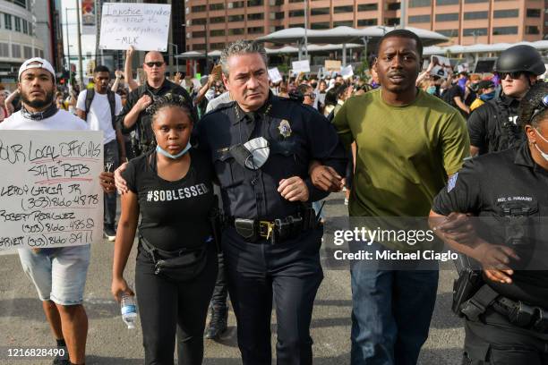 Denver Police Chief Paul Pazen embraces a woman as he marches with thousands of protesters during the fifth consecutive day of demonstrations in the...