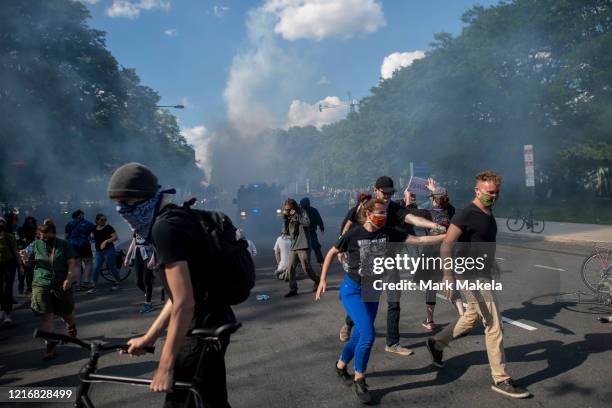 Protesters guide each other away from tear gas shot by the police after a march through Center City on June 1, 2020 in Philadelphia, Pennsylvania....