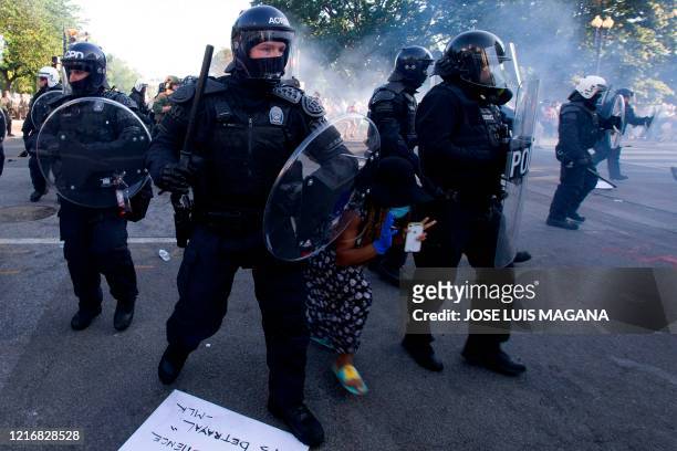 Demonstrator try to pass between a police line wearing riot gear as they push back demonstrators outside of the White House, June 1, 2020 in...
