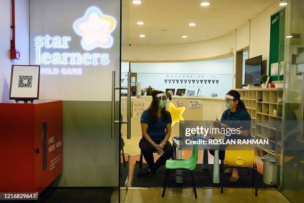 Teachers wait for children to arrive for health checks before entering the classroom as schools reopened in Singapore on June 2 as the city state...