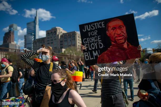 Protester holds a tribute poster to George Lloyd after a march through Center City on June 1, 2020 in Philadelphia, Pennsylvania. Demonstrations have...