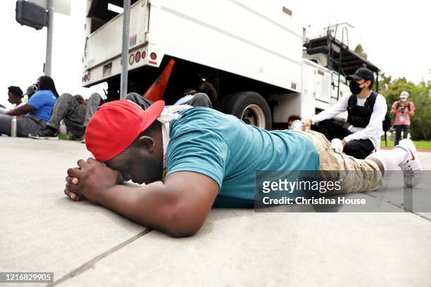Michael O'Quinn of Compton, prays during a peaceful protest where demonstrators laid down to approximate the time that George Floyd was on the...