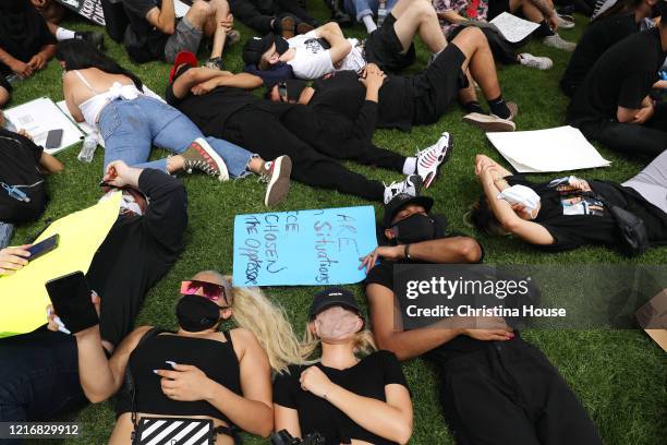 Demonstrators lay down to approximate the time that George Floyd was on the ground, during a peaceful protest outside the Cerritos Sheriff's Station...