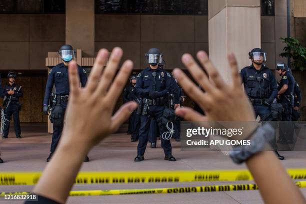 Demonstrator holds her hands up while she kneels in front of the Police at the Anaheim City Hall on June 1, 2020 in Anaheim, California, during a...