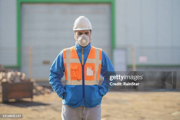 ingenieur trägt gasmaske vor der fabrik - hazardous workplace stock-fotos und bilder