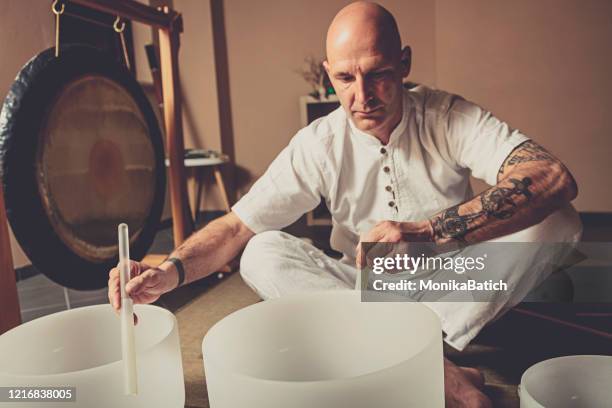 adult man playing meditative instruments - crystal stock pictures, royalty-free photos & images