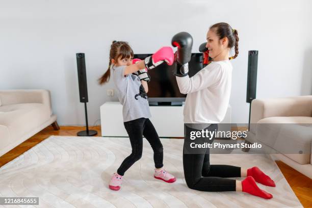 moeder en dochter oefenen boksen thuis - kids boxing stockfoto's en -beelden