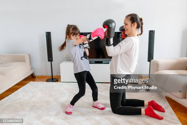 mother and daughter practicing boxing at home - desporto de combate imagens e fotografias de stock