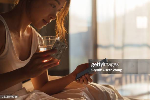cropped shot of young woman checking prescription with smart phone - diabetes pills stock pictures, royalty-free photos & images