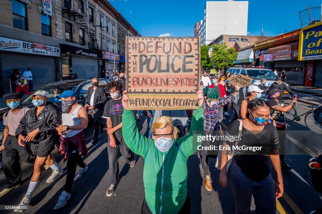 A participant holding a Defund Police sign at the protest.