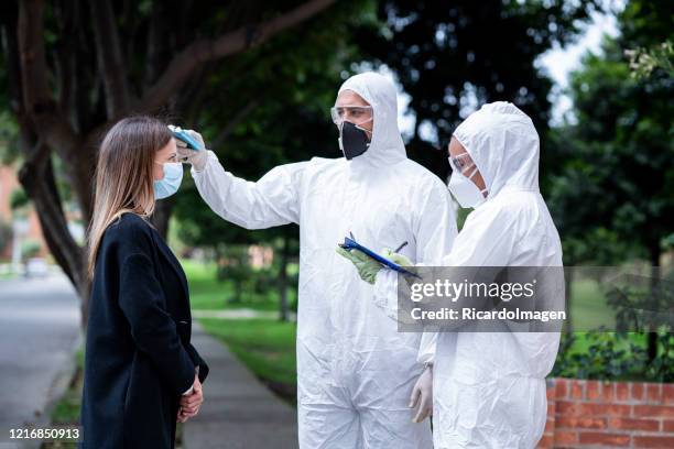 woman measure her temperature on the street - uncertainty pandemic stock pictures, royalty-free photos & images