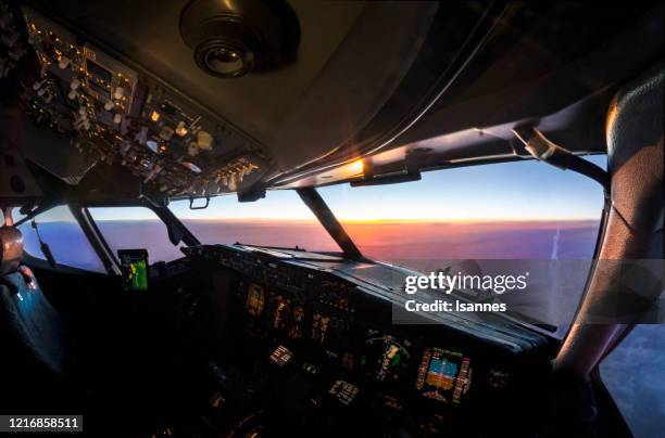 aerial sunset view from the cockpit of a jet airliner in flight - airplane cockpit stock pictures, royalty-free photos & images