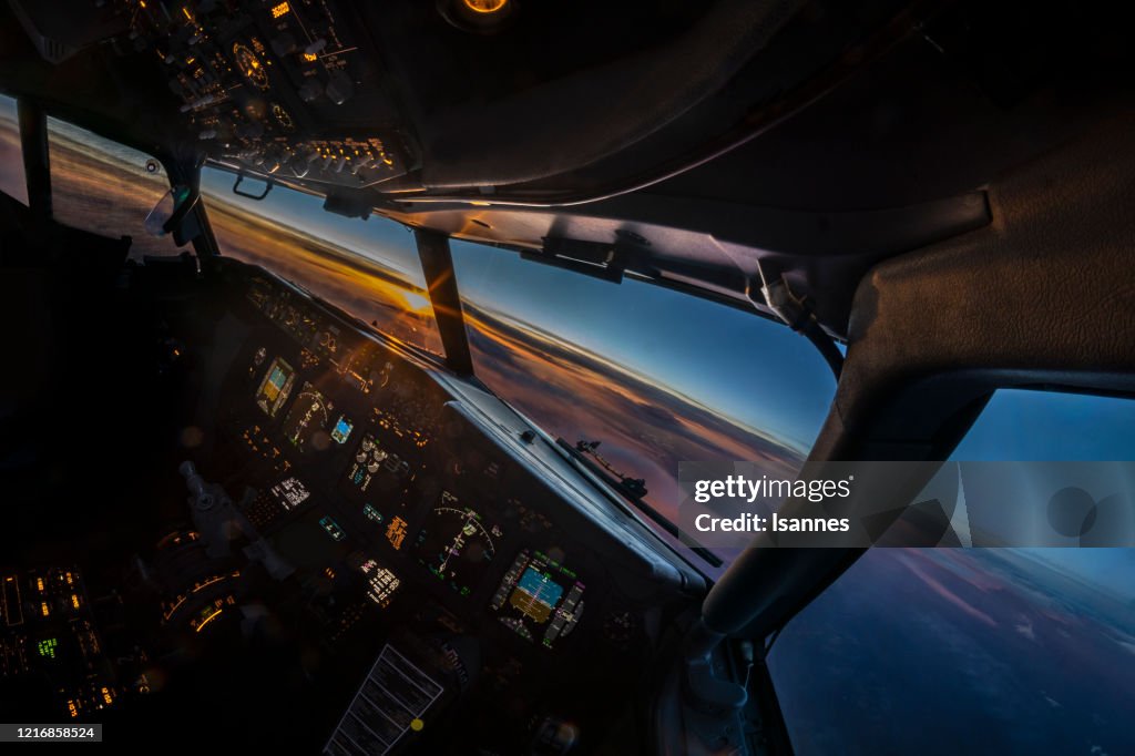 Luft-Sonnenuntergangsansicht aus dem Cockpit eines Düsenflugzeugs im Flug