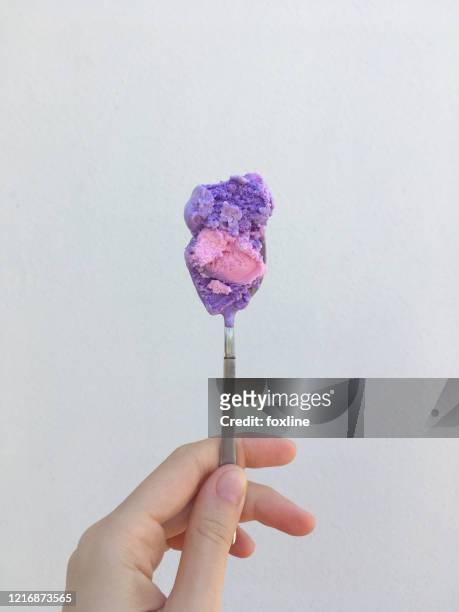 woman's hand holding a spoon of two tone ice-cream - femme bras tendu cuillère photos et images de collection
