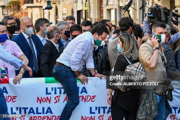 Head of the League party Matteo Salvini steps over a banner to join a march of his party united with the Brothers of Italy party and the centre-right...