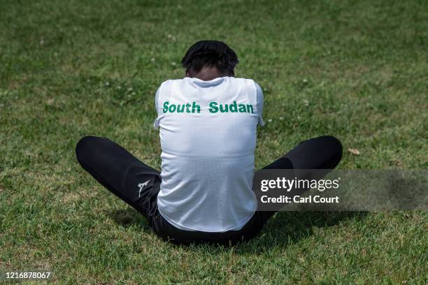 Year-old South Sudanese 100m and 200m sprinter, Moris Lucia, stretches as she prepares to train at an athletics track on June 2, 2020 in Maebashi,...