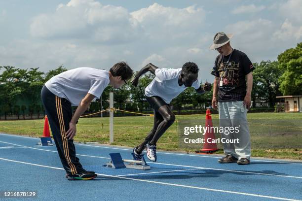 South Sudanese Olympic hurdler Joseph Akoon Akoon listens to a translator as coach Masanori Yamagishi gives instruction during a training session at...