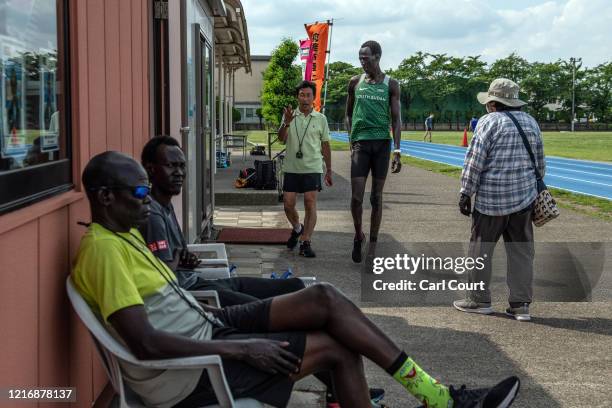 Year-old South Sudanese 1500m runner Abraham Majok Matet Guem chats with coach Yasuhiro Ito as he trains at an athletics track on June 2, 2020 in...