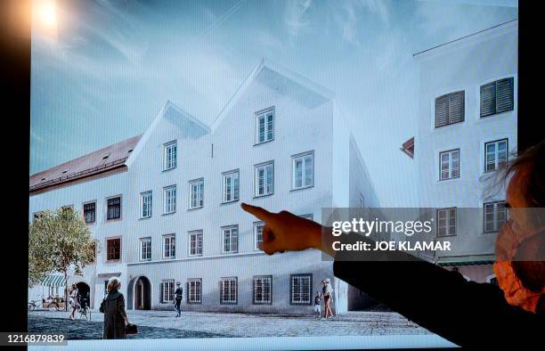 Man points his finger at a screen showing the chosen plan for the architectural redesign of Adolf Hitler's birth house, during a press conference at...