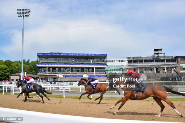 Jockeys and horses compete in the Read Andrew Balding On Betway Insider Handicap race in front of empty stands at Newcastle Racecourse on June 02,...