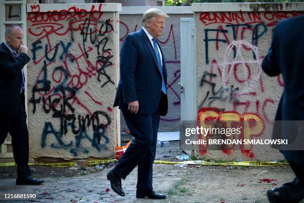 President Donald Trump walks back to the White House escorted by the Secret Service after appearing outside of St John's Episcopal church across...