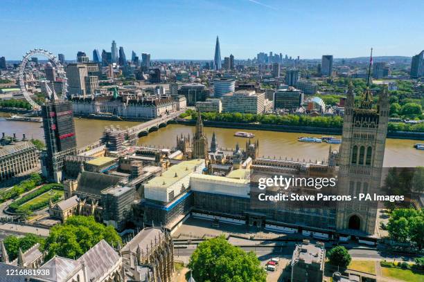 An aerial view of central London showing the Palace of Westminster, which contains the House of Commons and House of Lords, with the Elizabeth Tower...