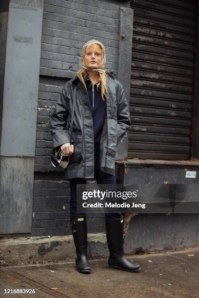 Model Hanne Gaby Odiele wears a clear floral rain scarf, black rain jacket, Proenza Schouler bag, blue jeans, and black Hunter rain boots after the...