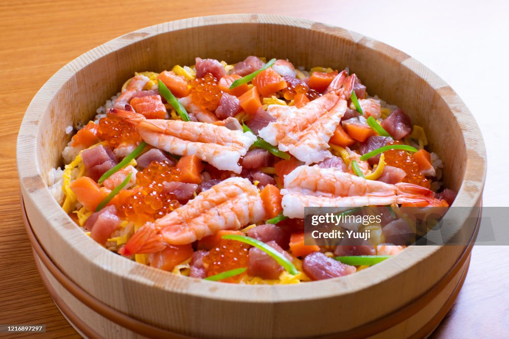 日本の家庭料理。チラシ寿司のレシピ。 寿司飯と煮た椎茸とニンジンを酢飯に混ぜ、目玉焼きを小さく切って上に置きます。また、生マグロ、サーモン、エビのゆで、サケローの盛り合わせ