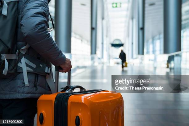 man walking with suitcase at airport terminal - airport security foto e immagini stock