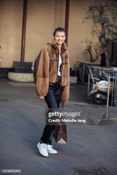 Model Mathilde Henning wears a brown fleece jacket, white t-shirt, black pants, white Adidas Stan Smith sneakers after the Alberta Ferretti show...