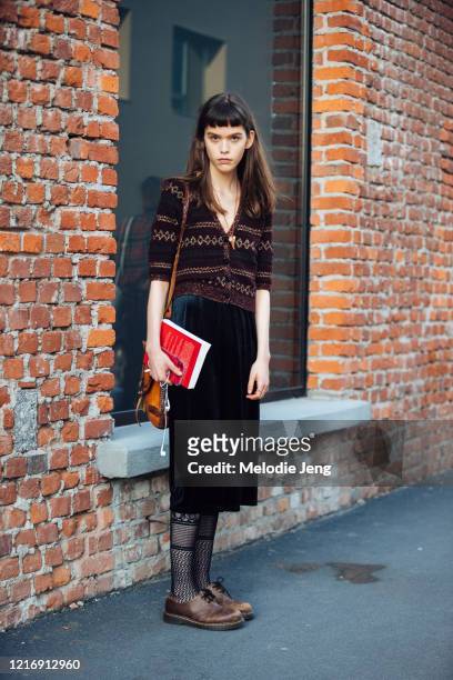 Model Jana Jonckheere wears a brown knit cardigan, green felt dress, lace stockings, and brown oxford shows after the Gucci show during Milan Fashion...