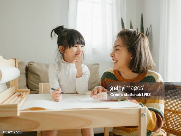 happy asian boy painting with crayon with his mother in living room at home. - family with one child stock pictures, royalty-free photos & images