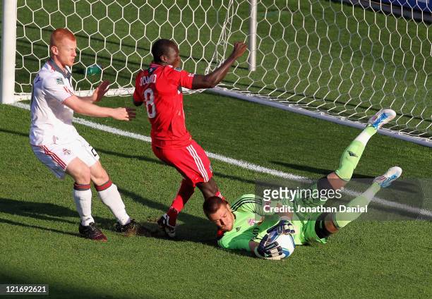 Milos Kocic of Toronto FC makes a save on a shot by Dominic Oduro of the Chicago Fire as Richard Eckersley defends during an MLS match at Toyota Park...