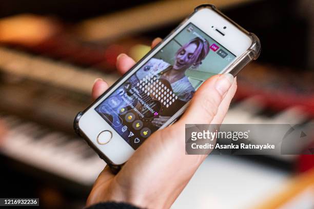 Musician Greta Stanley performance is viewed via a live streamed seen on a phone as part of Isol-Aid on April 05, 2020 in Melbourne, Australia. The...