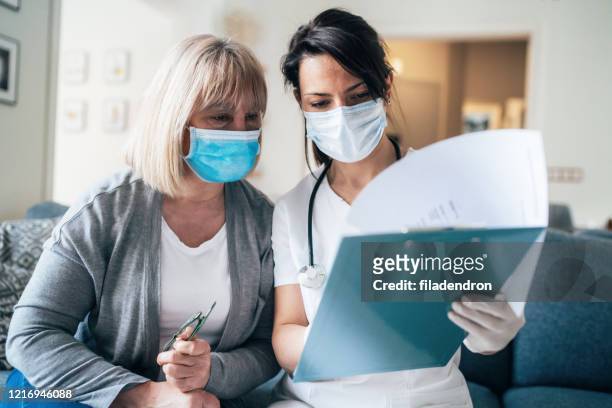 doctor's home visiting during the quarantine - explaining stock pictures, royalty-free photos & images