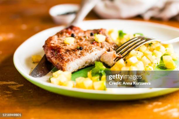 roasted pork chop with pineapple salsa and mint on a plate on a wooden table, selective focus - kotlett med ben bildbanksfoton och bilder