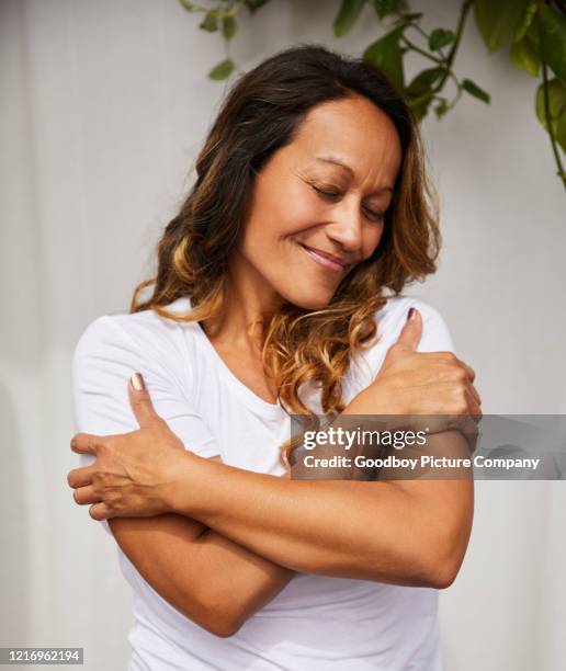 mulher madura sorridente abraçando-se em seu pátio - beautiful polynesian women - fotografias e filmes do acervo