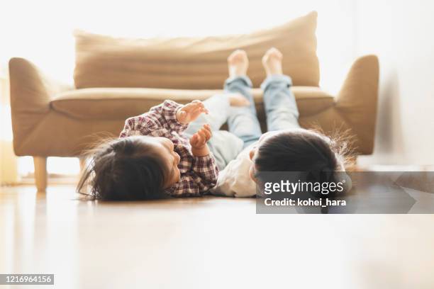 fratelli rilassati a casa - pavimento foto e immagini stock