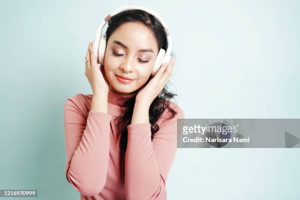 happy asian teenage girl listen the music song in wireless headphone from mp3 player technology. relaxation and music lover concept. - classical stock photos et images de collection