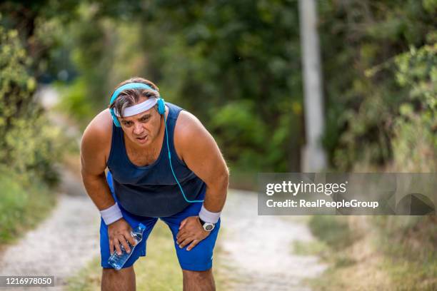 purposeful overweight man running in park, out of breath, persistent motivation - dyspnea stock pictures, royalty-free photos & images