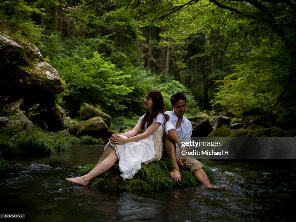 Lovers who draws close on rock of brook