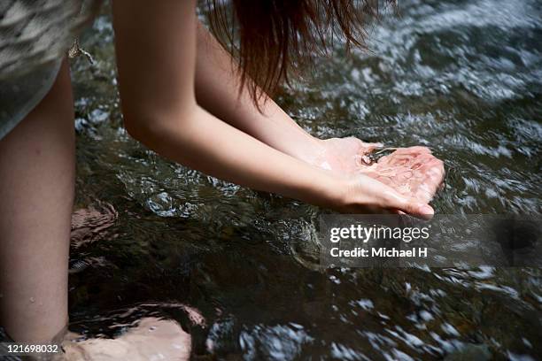 woman who scoops water of beautiful river - clean water stock pictures, royalty-free photos & images