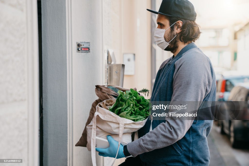 A man is delivering a bag of vegetables and fruit