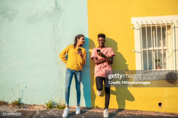 smiling young couple using mobile phone. - indian ethnicity south africa stock pictures, royalty-free photos & images